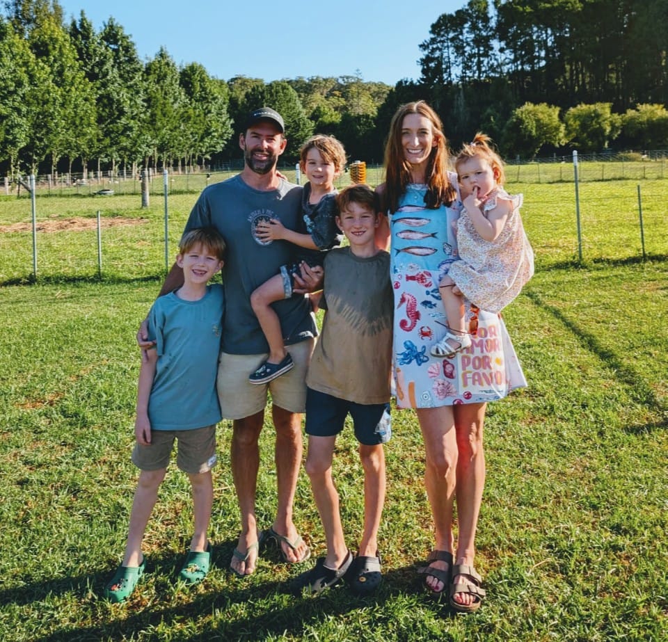Annabelle and Justin outdoors on the grass with their four children on a sunny afternoon